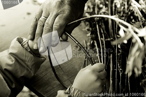Image of Man teaching child making a wicker basket