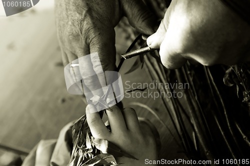 Image of Man teaching child making a wicker basket