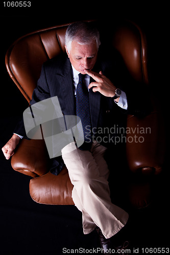 Image of Pensive mature businessman seated on a chair