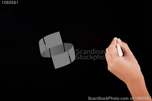 Image of Left Hand writing on a blackboard in white