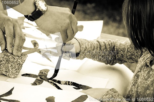 Image of Teacher Helping Student drawing hieroglyph