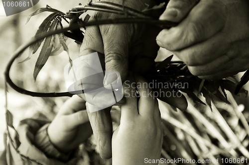 Image of Man teaching child making a wicker basket