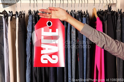 Image of hand with sell letters plate in a store