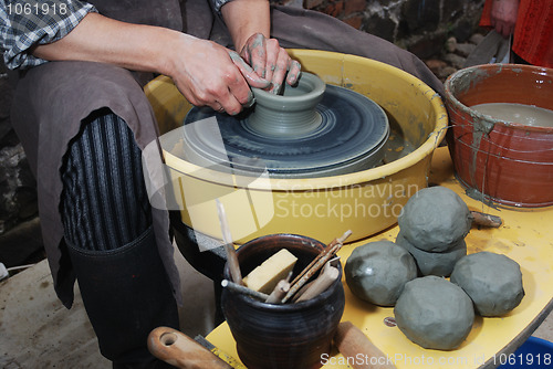 Image of potter's wheel and hands of craftsman