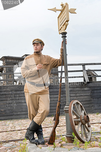 Image of Retro style picture with soldier at tram stop.