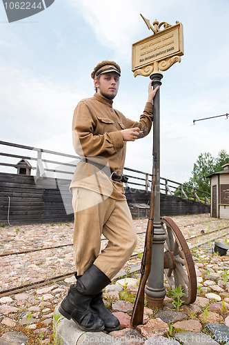 Image of Retro style picture with soldier at tram stop.