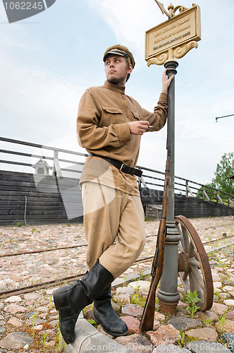 Image of Retro style picture with soldier at tram stop.