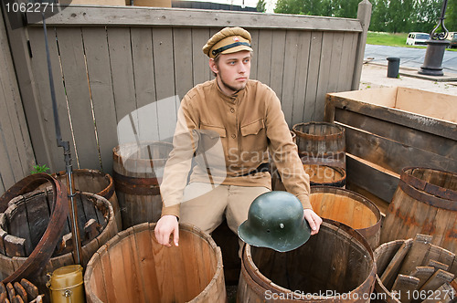 Image of Retro style picture with soldier sitting on the butt