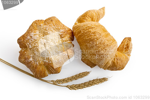 Image of Croissant and bread roll with stems of wheat