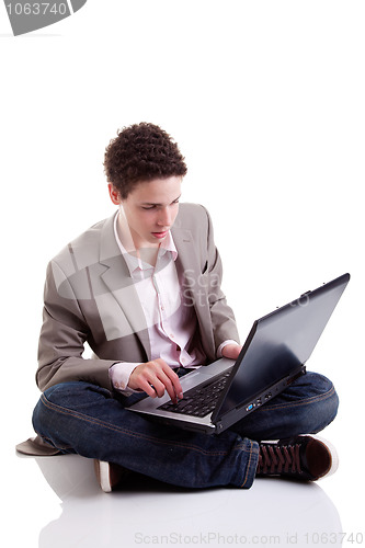 Image of Young man typing and looking at screen of laptop