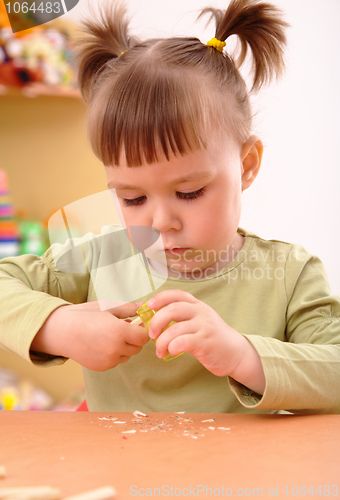 Image of Little girl sharpening a pencil
