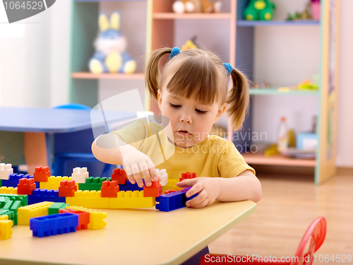 Image of Little girl play with building bricks in preschool