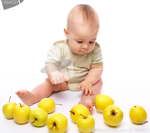 Image of Little boy play with apples