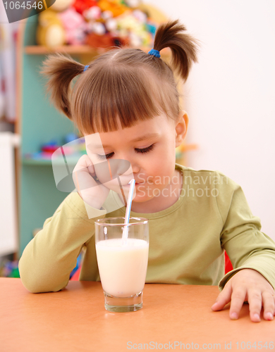 Image of Gloomy little girl drinks milk