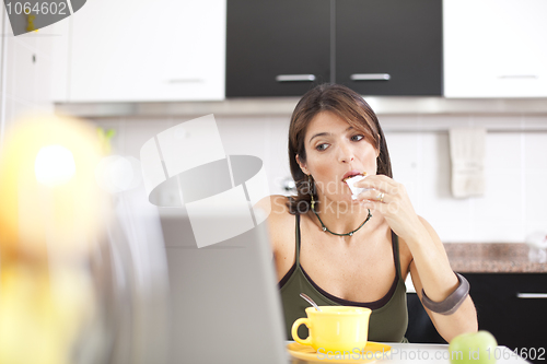 Image of Modern woman reading e-mails at her breakfast