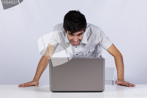 Image of Happy businessman looking to his laptop