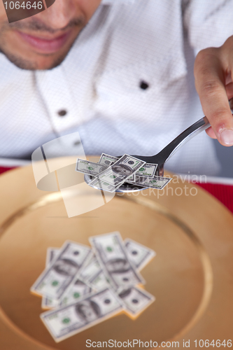 Image of Man eating little dollar banknote