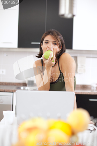 Image of Modern woman reading e-mails at her breakfast