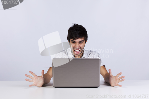 Image of Young man shouting to a laptop