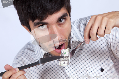 Image of Man eating little dollar banknote