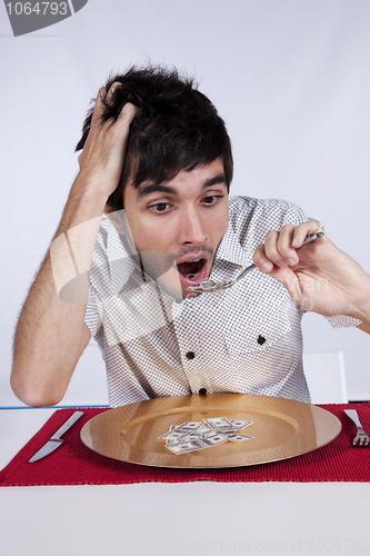 Image of Man eating little dollar banknote