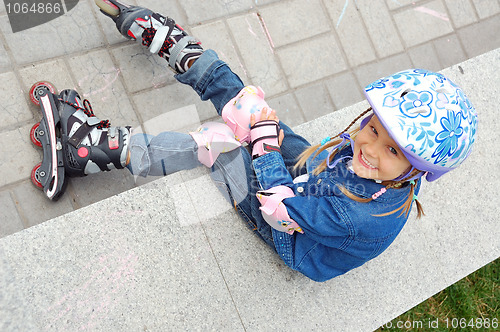 Image of child with rollerskates and protective helmet and pads