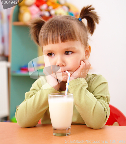 Image of Gloomy little girl drinks milk