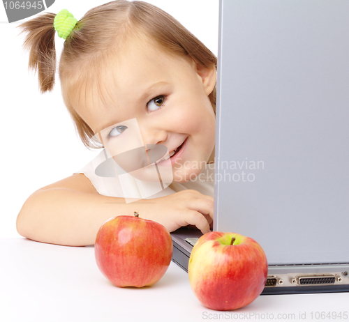 Image of Cute little girl is looking out from her laptop