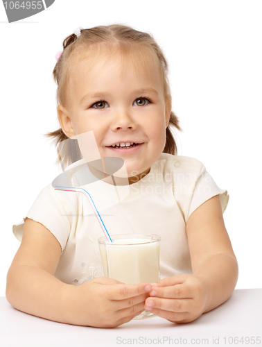 Image of Little girl drinks milk using drinking straw