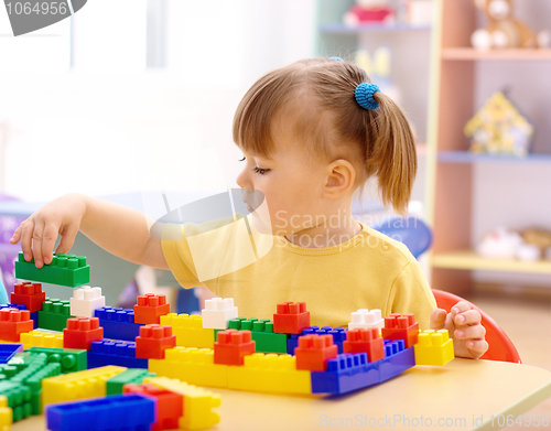Image of Little girl play with building bricks in preschool