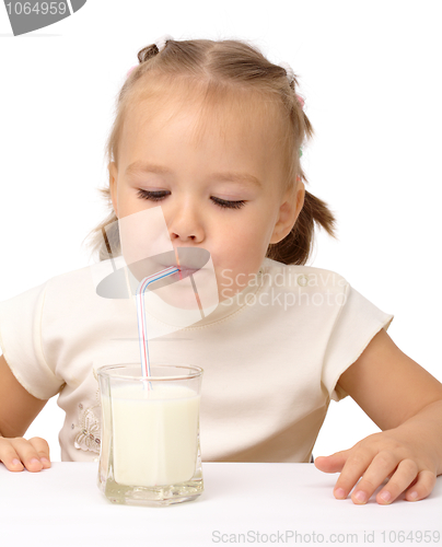 Image of Little girl drinks milk using drinking straw