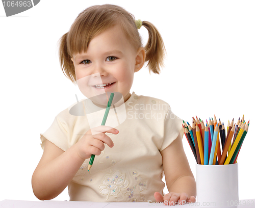 Image of Cute child draws with color pencils