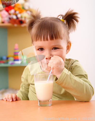 Image of Happy little girl drinks milk