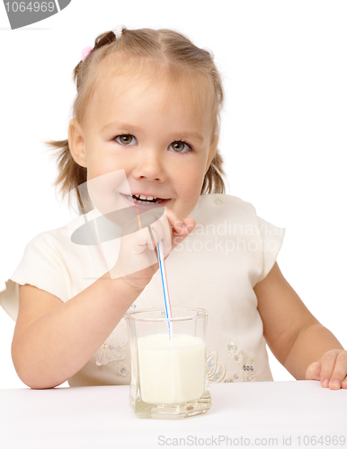 Image of Little girl drinks milk using drinking straw