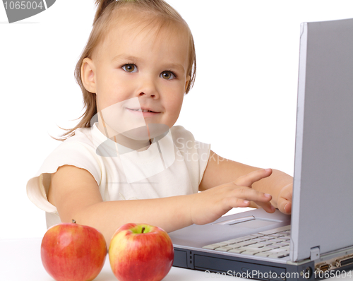 Image of Cute little girl with laptop and two apples