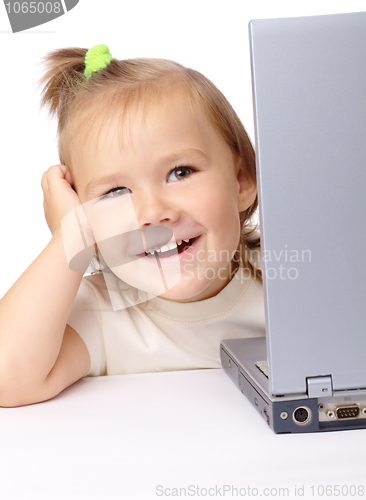 Image of Cute little girl is looking out from her laptop