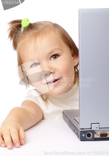 Image of Cute little girl is looking out from her laptop