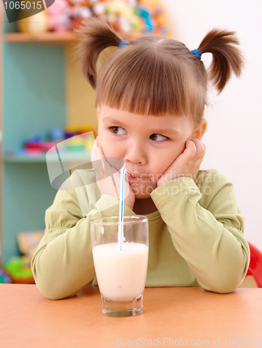 Image of Gloomy little girl drinks milk