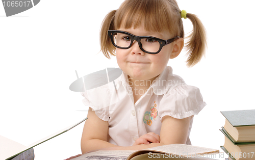 Image of Happy little girl with book wearing black glasses