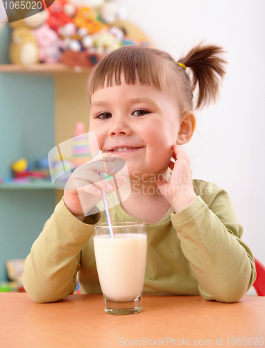 Image of Happy little girl drinks milk