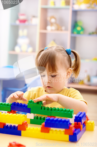 Image of Little girl play with building bricks in preschool