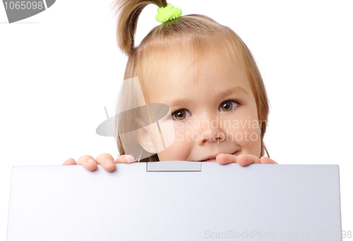 Image of Cute little girl is looking out from her laptop