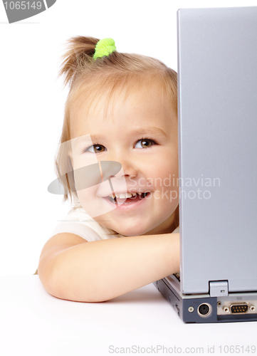 Image of Cute little girl is looking out from her laptop