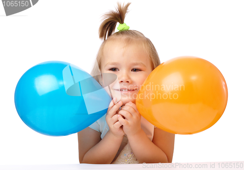 Image of Cute little girl with two colored balloons