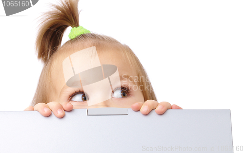 Image of Cute little girl is looking out from her laptop