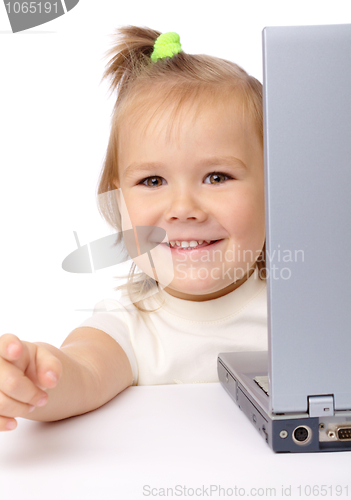 Image of Cute little girl is looking out from her laptop