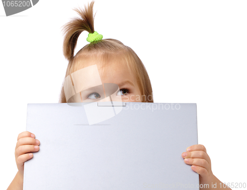 Image of Cute little girl is looking out from her laptop