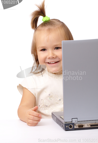 Image of Cute little girl is looking out from her laptop