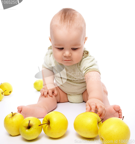 Image of Little boy play with apples