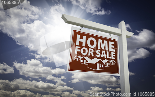 Image of Red Home For Sale Real Estate Sign Over Clouds and Sky